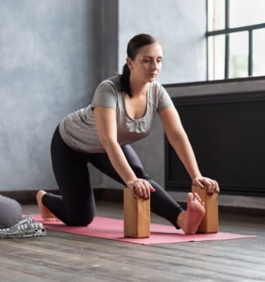 woman doing stretching exercise using props block Naturheilpraxis Aachen