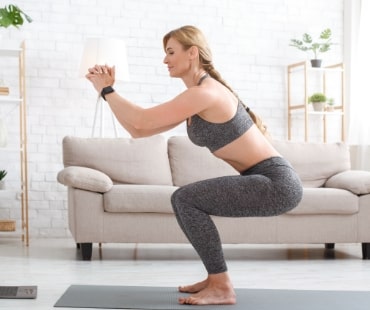 woman with fitness tracker crouches and watches at Naturheilpraxis Aachen